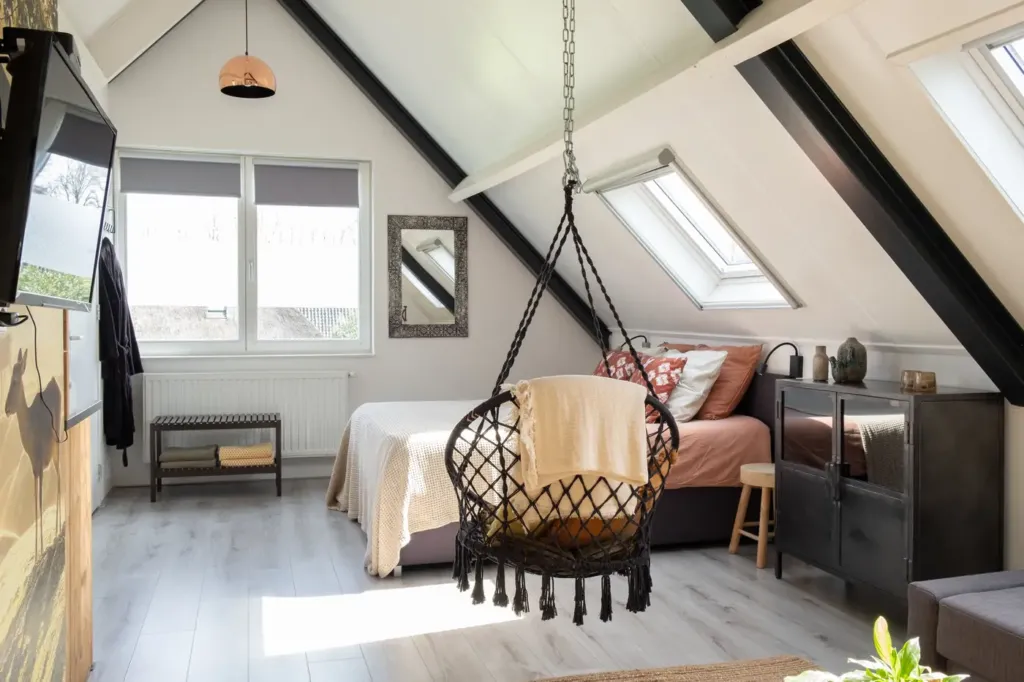 De Herten kamer: lichte zolderkamer met hangstoel, bank en boxspring onder dakramen